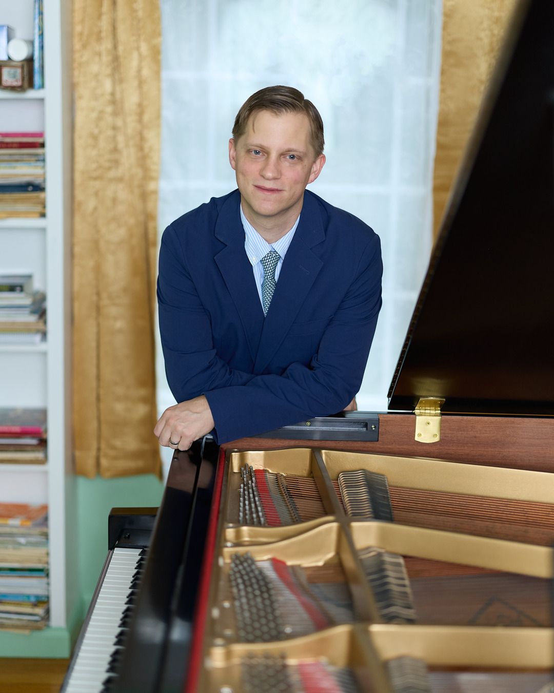 Joe Infurchia standing at his grand piano