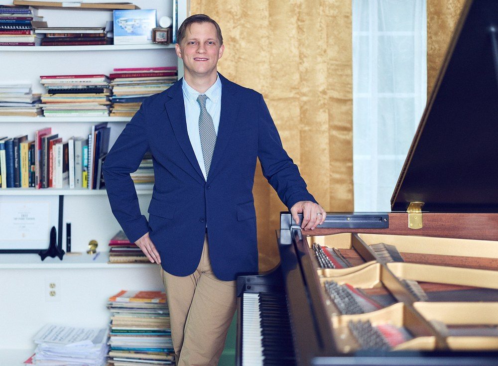 Joe Infurchia beside his grand piano in his Connecticut studio